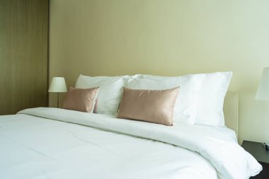 Yatak dekorasyonunda beyaz rahat yastık.