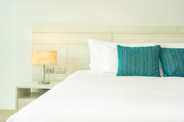 Yastık ve battaniye yatağın üzerinde, içinde lamba süslemesi var.