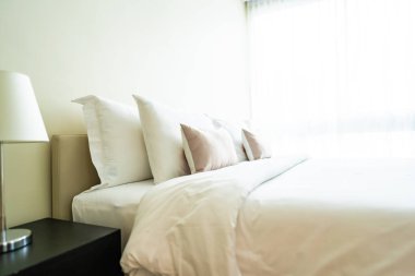 Yatak dekorasyonunda beyaz rahat yastık.