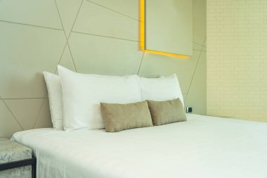 Yatak dekorasyonunda beyaz rahat yastık.