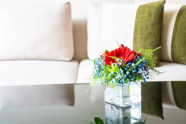 Wazon kwiatów na stole z poduszki na kanapie ozdoba — Zdjęcie stockowe