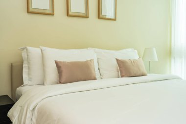 Yatak dekorasyonunda beyaz rahat yastık.