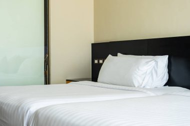 Yastık ve battaniye yatağın üzerinde, içinde lamba süslemesi var.