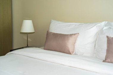 Yatak dekorasyonunda beyaz rahat yastık.