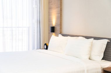 Yatak dekorasyonunda beyaz rahat yastık.