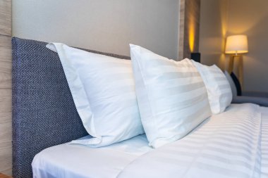 Yatak dekorasyonunda beyaz rahat yastık.