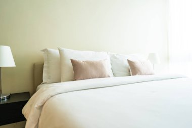 Yatak dekorasyonunda beyaz rahat yastık.