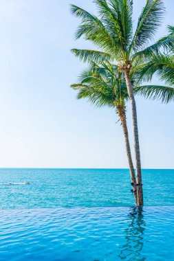 Otelin havuzunda hindistan cevizi palmiyeli lüks bir yüzme havuzu.