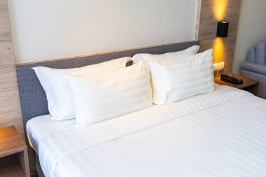 Yatak dekorasyonunda beyaz rahat yastık.