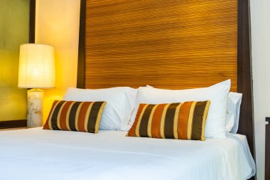 Yatak dekorasyonunda beyaz rahat yastık.