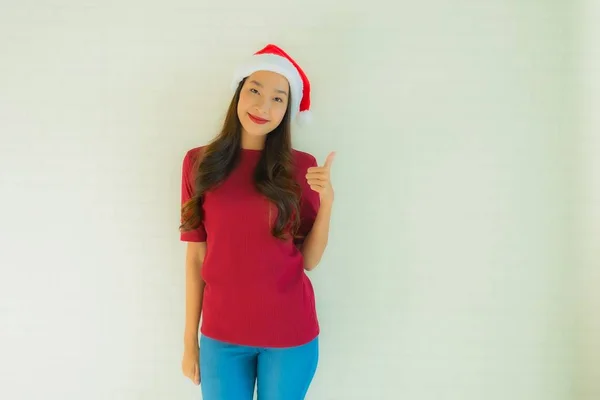 Ünlü olmak için Noel Baba şapkası takan güzel Asyalı genç kadınların portresi. — Stok fotoğraf