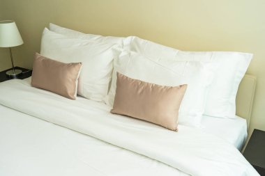 Yatak dekorasyonunda beyaz rahat yastık.