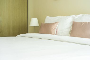 Yatak dekorasyonunda beyaz rahat yastık.