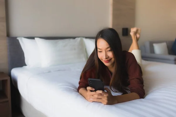 Портрет красивих молодих азіатських жінок, що використовують мобільний телефон на ліжку — стокове фото
