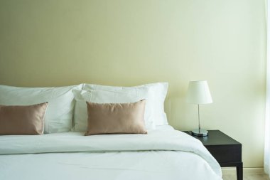 Yatak dekorasyonunda beyaz rahat yastık.