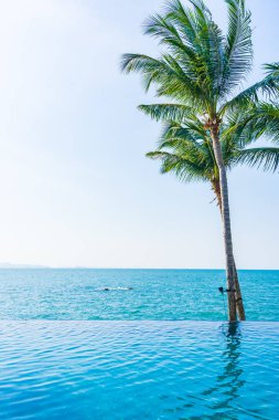 Otelin havuzunda hindistan cevizi palmiyeli lüks bir yüzme havuzu.