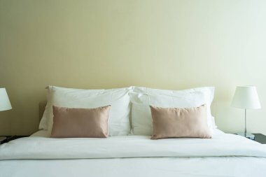 Yatak dekorasyonunda beyaz rahat yastık.