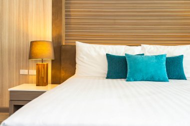 Yatak dekorasyonunda beyaz rahat yastık.