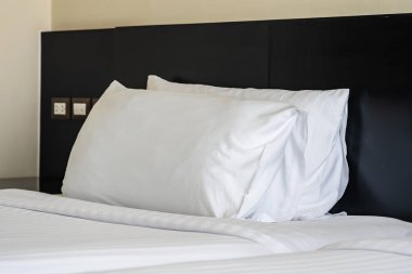 Yastık ve battaniye yatağın üzerinde, içinde lamba süslemesi var.