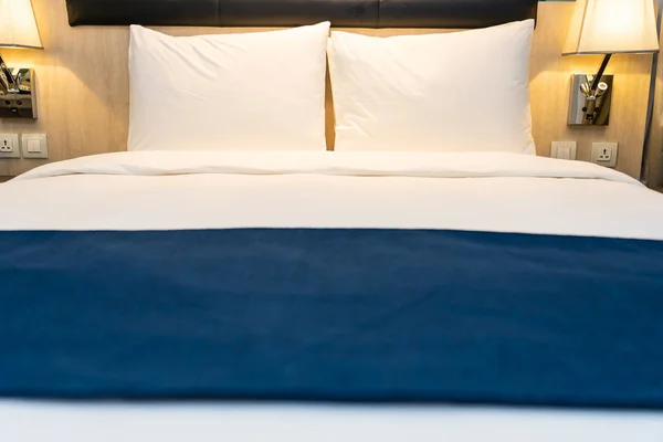 Белая удобная подушка и одеяло на постельном белье в спальне — стоковое фото