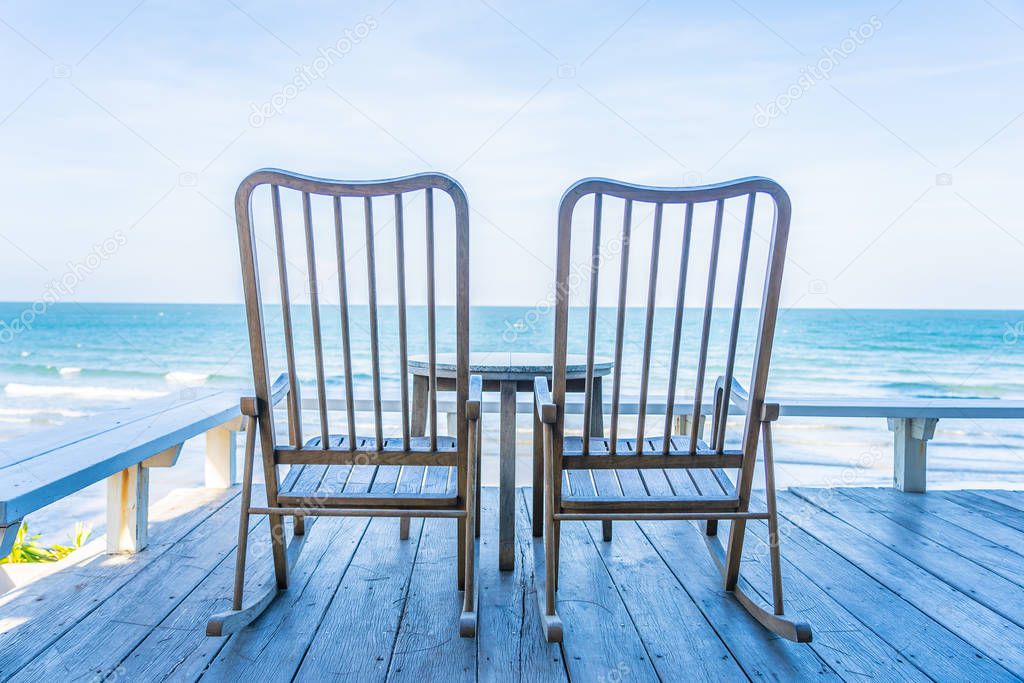 Empty wood chair and table at outdoor patio with beautiful tropi