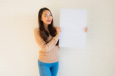 Güzel Asyalı genç kadınların portresi boş beyaz kağıt yaban domuzu gösteriyor.