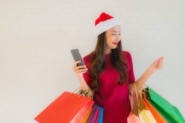 Güzel bir Asyalı kadın portresi Noel Baba şapkası giyer.