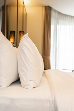 Yastık ve battaniye yatağın üzerinde, içinde lamba süslemesi var.