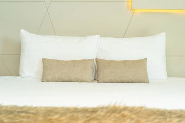 Yatak dekorasyonunda beyaz rahat yastık.