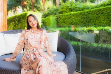 Güzel Asyalı genç kadınların portresi. Mutlu bir gülümseme. Kanepeye otur.