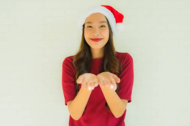 Ünlü olmak için Noel Baba şapkası takan güzel Asyalı genç kadınların portresi.