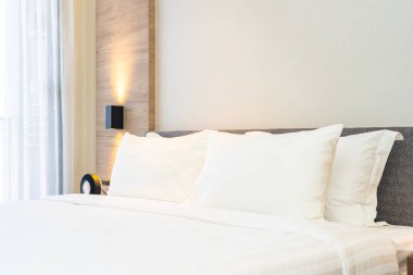 Yatak dekorasyonunda beyaz rahat yastık.