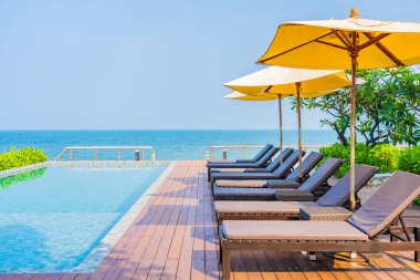 Dışarıda yüzme havuzu etrafında güzel boş bir sandalye şemsiyesi.
