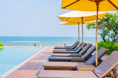 Dışarıda yüzme havuzu etrafında güzel boş bir sandalye şemsiyesi.