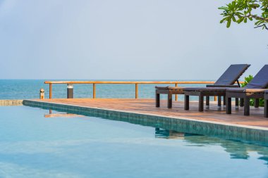 Dışarıda yüzme havuzu etrafında güzel boş bir sandalye şemsiyesi.