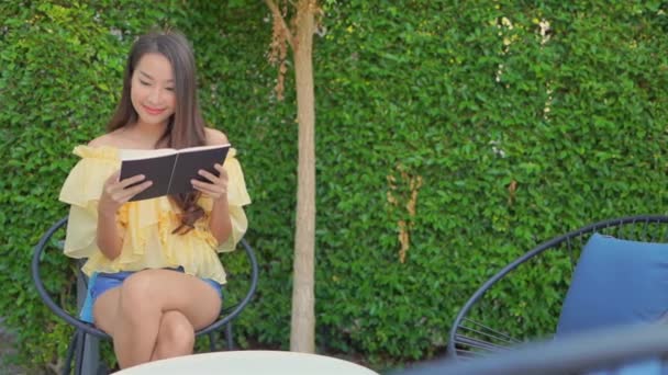 Yeşil Bahçede Kitap Okuyan Asyalı Güzel Bir Kadının Görüntüleri — Stok video