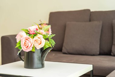 Yastık ve kanepe dekorasyonlu vazo çiçeği.