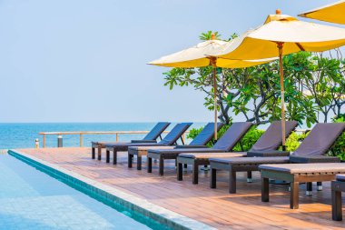 Dışarıda yüzme havuzu etrafında güzel boş bir sandalye şemsiyesi.