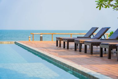 Dışarıda yüzme havuzu etrafında güzel boş bir sandalye şemsiyesi.