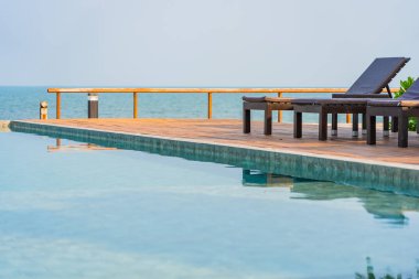 Dışarıda yüzme havuzu etrafında güzel boş bir sandalye şemsiyesi.