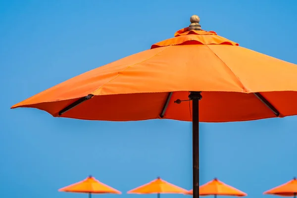 Parapluie avec beau fond bleu ciel presque mer océan bea — Photo