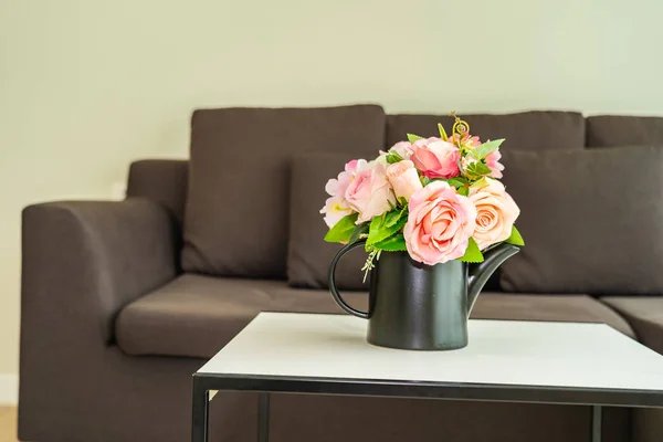 枕とソファの装飾が施されたテーブルの上の花瓶の花インテリア — ストック写真