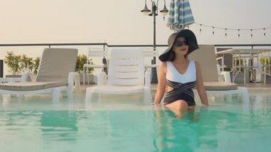 Güzel Asyalı bir kadının oteldeki havuzda dinlenirken çekilmiş görüntüleri.