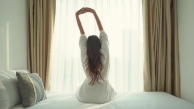 Evdeki yatakta uzanan güzel Asyalı kadının görüntüleri.