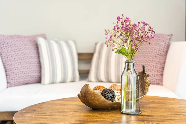 Vaso de flores na mesa com travesseiro no sofá decoração interior de — Fotografia de Stock