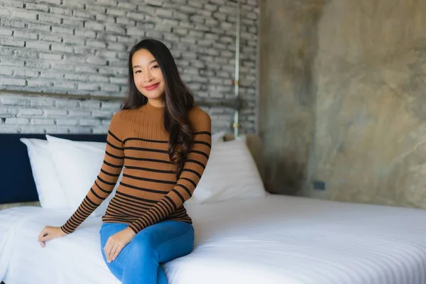 Ung asiatisk kvinna glad leende koppla av på sängen i sovrummet — Stockfoto