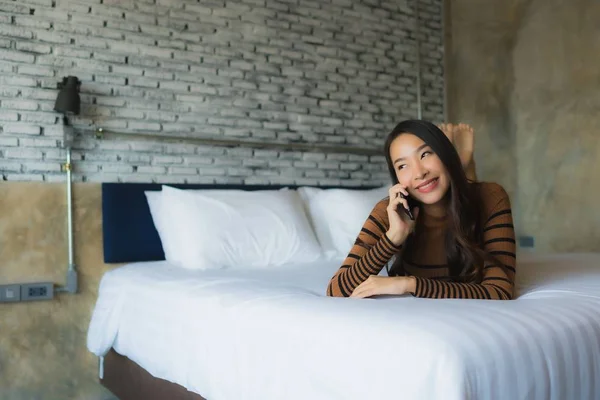 Fiatal ázsiai nő használ mobiltelefon az ágyban — Stock Fotó