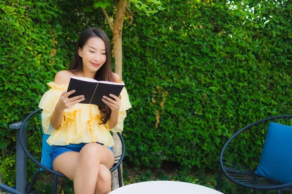 Young asian woman read book around outdoor garden nature
