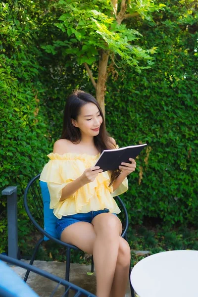 Young asian woman read book around outdoor garden nature