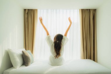 Genç Asyalı mutlu gülümseme. Yatak odasında rahatla.